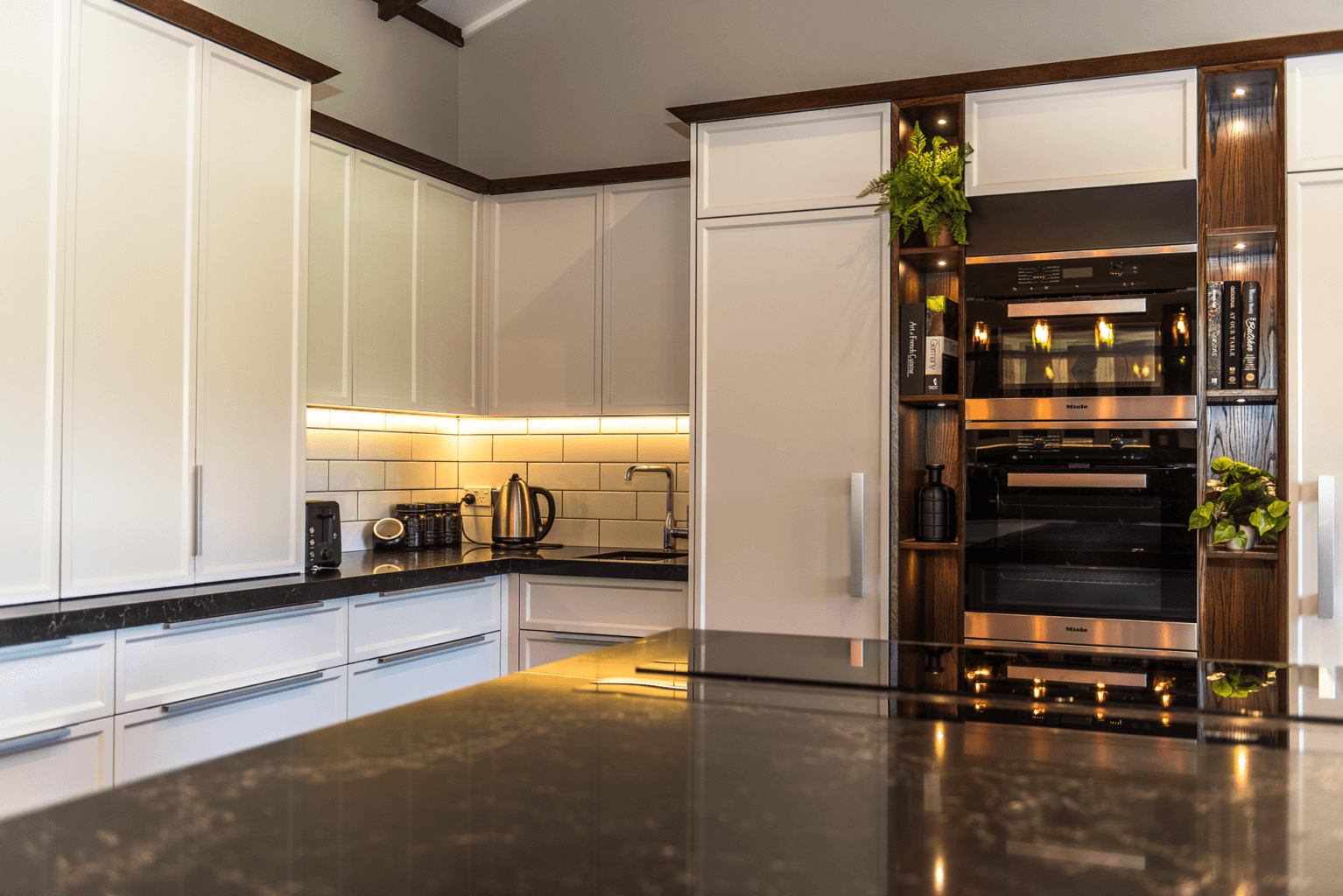 Feature illuminated shelves beside oven tower.